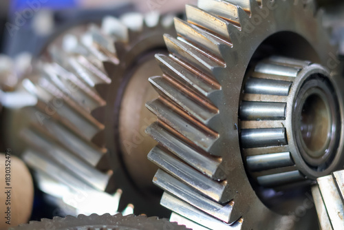 Close-up of a disassembled automotive transmission main shaft, featuring a series of stacked helical gears and synchronization rings, symbolizing complex mechanical engineering and vehicle repair.