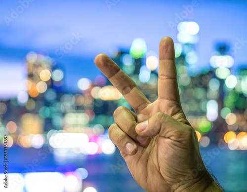 Peace sign gesture with city lights bokeh background