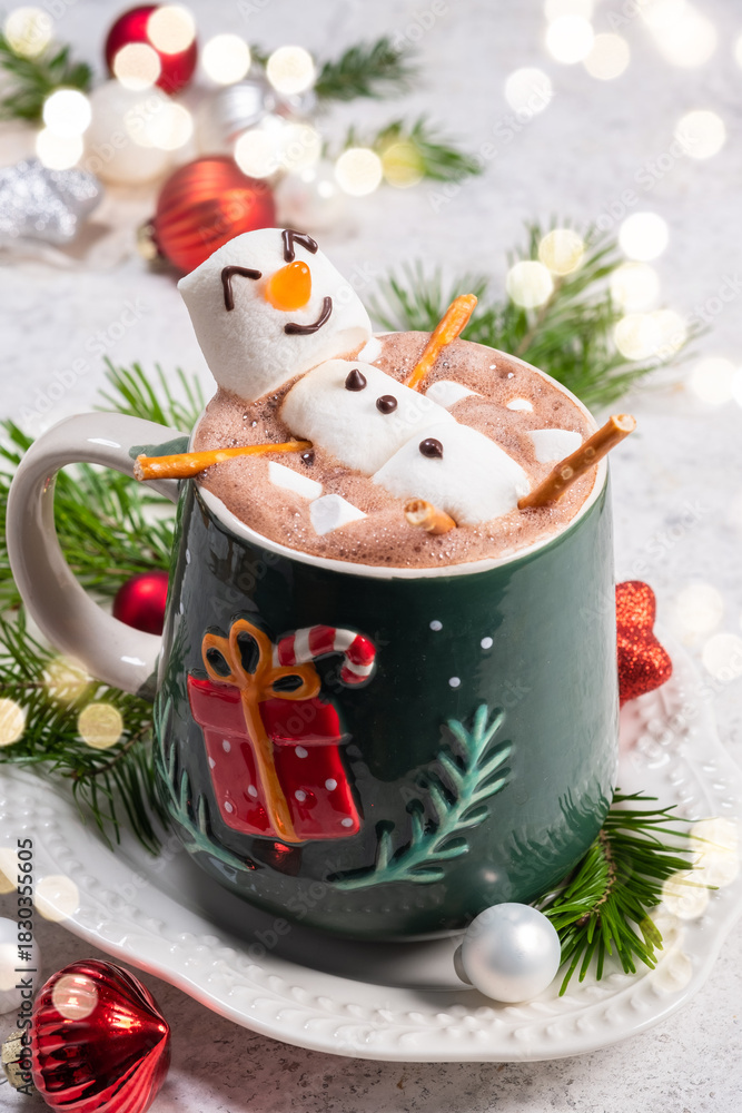 Obraz premium Cozy winter scene with festive hot chocolate topped by a playful snowman in a decorated mug
