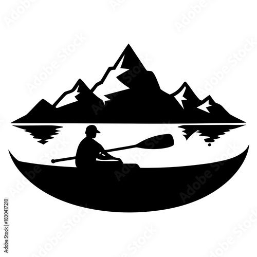 Silhouette of a kayaker paddling on a lake with mountains in the background