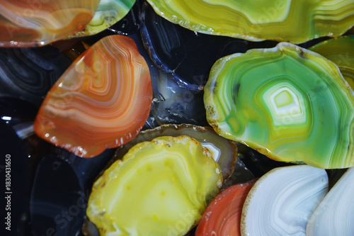 Several uncut green agate stones with a beautiful natural wavy pattern lie on a table. Semi-precious natural stones and minerals.