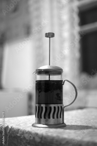 Coffee in a French press on a wooden table.