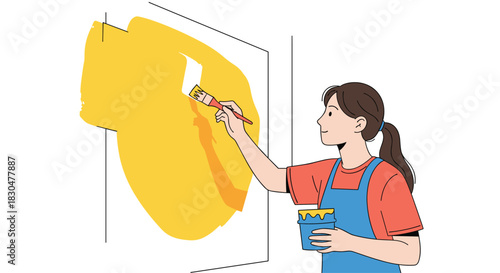 Happy young woman painting a large section of a white wall yellow with a paintbrush, engaged in a home renovation project.