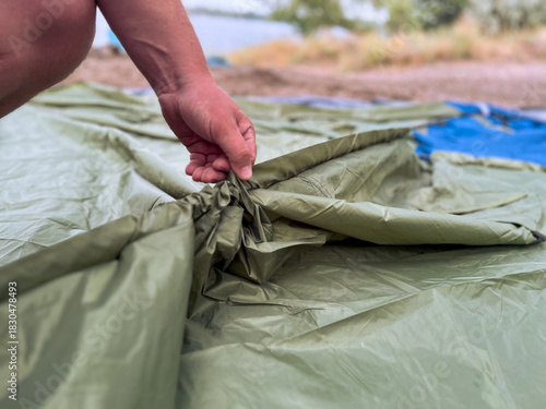 Man setting up camping tent on beach
