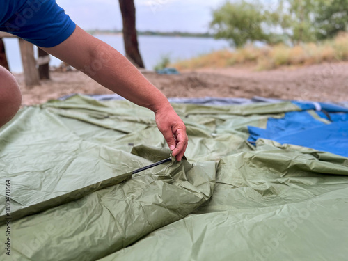 Man setting up camping tent for outdoor recreation