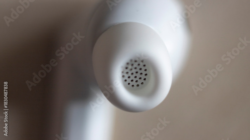 Photos Close-up of circular perforated design on white earbuds