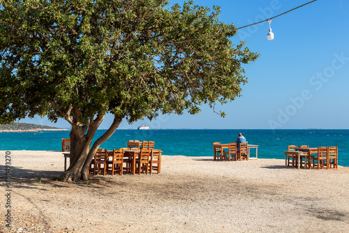 Fototapeta Naklejka Na Ścianę i Meble -  Wooden tables and chairs in a beach park on the Mediterranean coast.