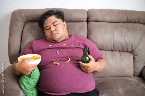 Big Man Takes Nap on Sofa While Drinking Beer and Snacking