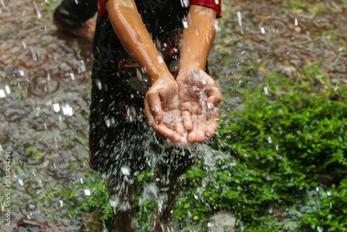 hands with splashes of falling rain