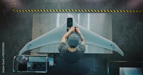 Technician Servicing Large Surveillance Drone. Man Performing Maintenance or Integrating Systems Into Large Aerial Drone. Concept Meticulous Process of UAV Servicing and Quality Control. Top View.