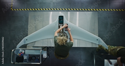 Woman in Camouflage Uniform Working on Next Generation Drone. Female Soldier Installing Electronic Parts Into Surveillance Drone. Concept of Advanced Military Research and Development. Top View.