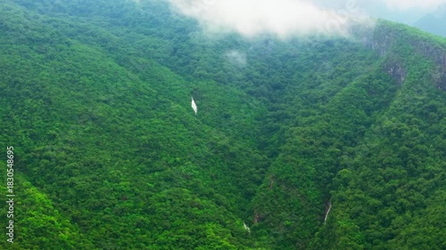 Aerial Dolly In Toward Hidden Cascading Waterfalls in Lush Green Mountains