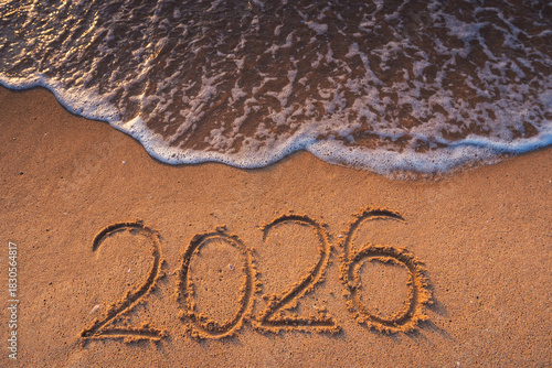 Fototapeta Naklejka Na Ścianę i Meble -  Happy New Year 2026 concept, number 2026 lettering on the beach sand at sunrise