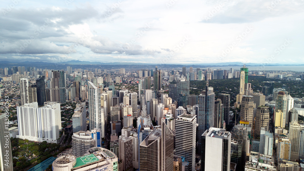 Obraz premium Stunning aerial panorama of Makati City in Metro Manila, Philippines, showing a dense cluster of modern skyscrapers and high-rise towers.