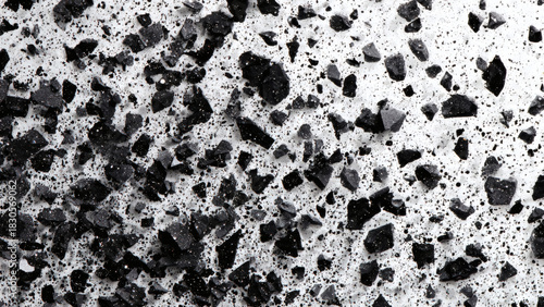 Detailed close-up of a textured surface with sharp black granules embedded in a light concrete background, creating a monochrome abstract pattern