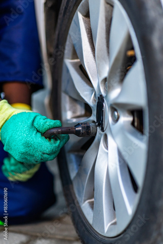 Close-up, African mechanic hands changing a car tire in his workshop