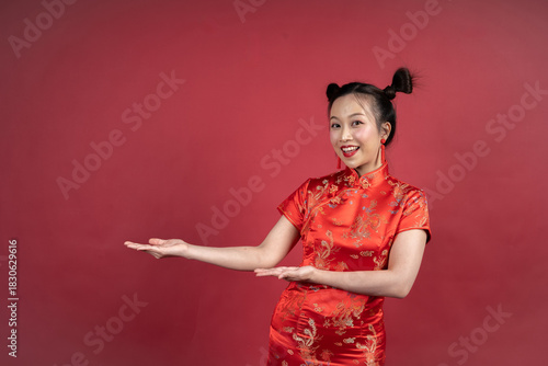 Friendly Chinese female gesturing to side for Lunar New Year advertisement