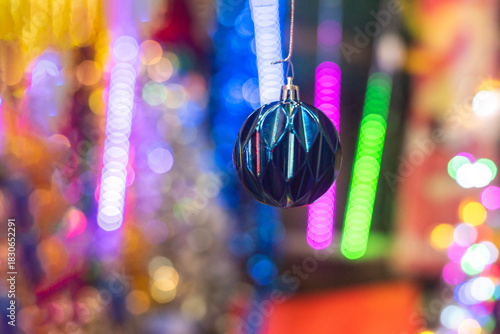 Striking Blue Christmas Bauble with Geometric Pattern Against Intense Bokeh Lights