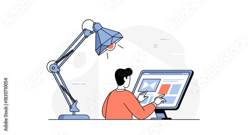 Designer interacting with digital elements on the computer screen under the lamp light setup