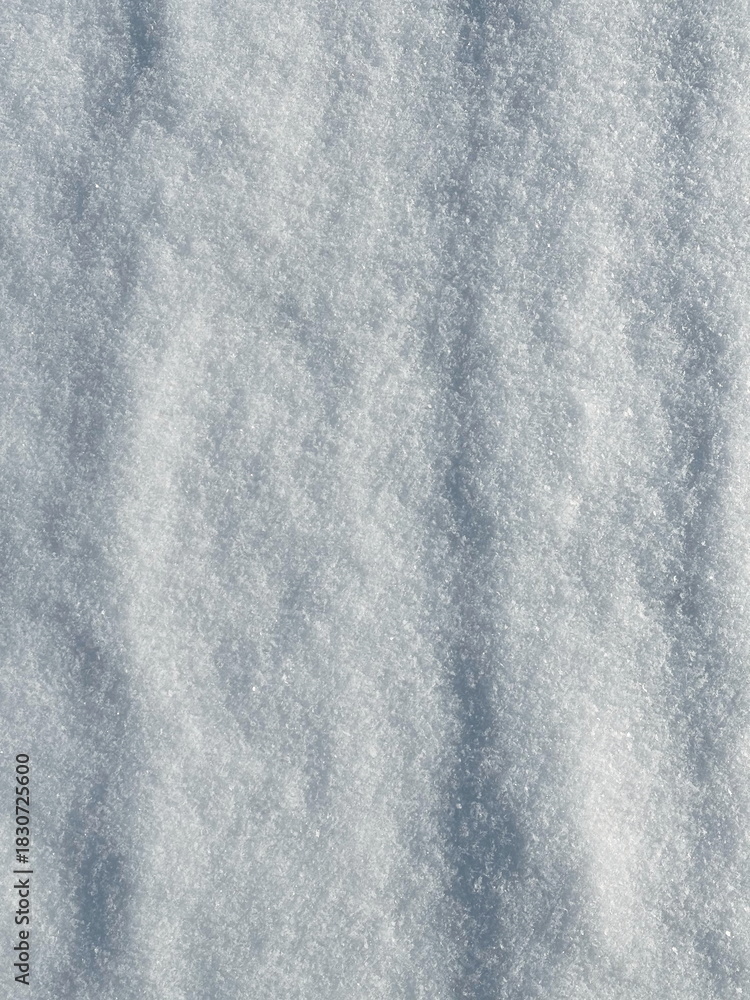 Fototapeta premium Close-up view of smooth snow surface with natural winter shadows.