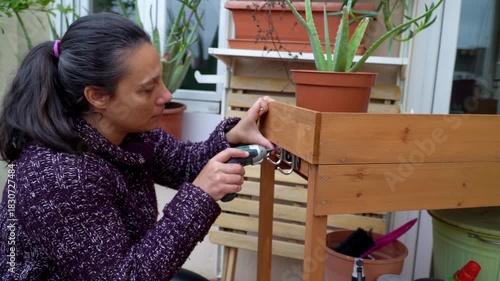Woman doing renovation and DIY gardening with cordless screwdriver