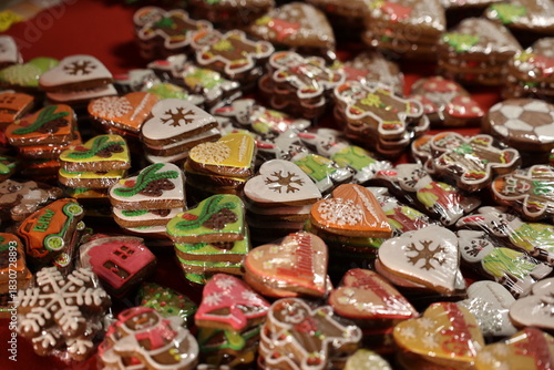 Piles of sweet, colorful gingerbread cookies with heart and Christmas designs for sale at a market