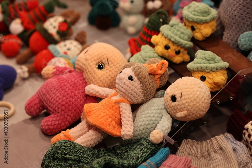 Close-up of soft, colorful, handmade crochet toys and stuffed dolls displayed for sale at a market