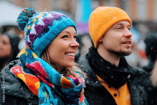 A joyful diverse couple beams with happiness, sporting colorful knit beanies and matching scarves as festive decorations, capturing the heartwarming spirit of a cozy winter celebration.