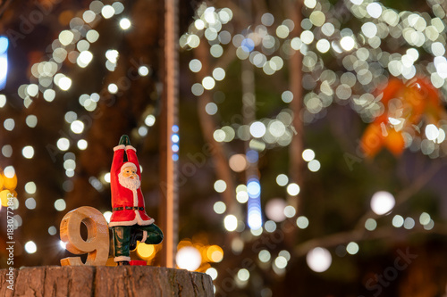 ヨガポーズのサンタ人形とイルミネーションのボケが広がるクリスマス風景