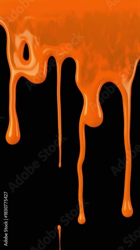 Viscous orange liquid, like melted caramel or glossy paint, flows and drips in thick streams against a stark black surface
