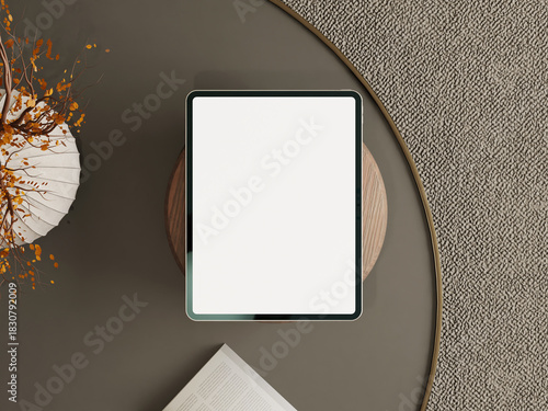 Tablet mockup with blank screen placed on a round table with autumn leaves and decorative vase.