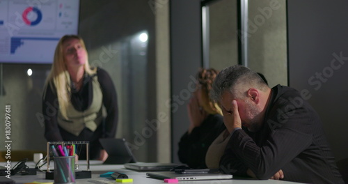 Female boss publicly scolding male employee during tense office meeting, man hides face in shame as colleagues look on, highlighting workplace conflict and humiliation