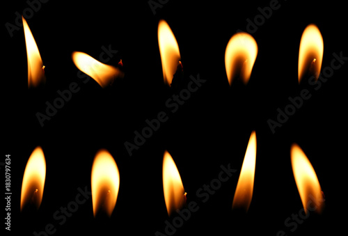 set candle flame is burning at night in close range, yellow light isolated on a black background. Concept for taking graphics for birthdays, Halloween, and Christmas. glow wick