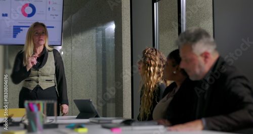 Female boss scolds employee for checking phone during presentation in tense office meeting, asserting authority and addressing disrespectful behavior in corporate setting