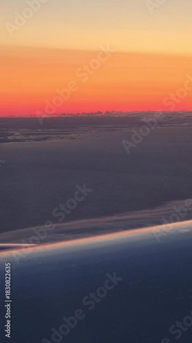 aerial gradient orange sunset dusk sky plane wing view vertical video