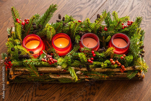 Advent wreath made of branches with two candles burning on Christmas Eve