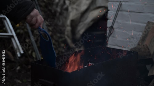 The vibrant flames rising inside the barbecue grill, with intense fire and swirling sparks, create a dramatic and dynamic scene.
