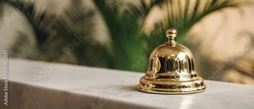 The Service Bell on a Marble Reception Counter with Tropical Plants in Background
