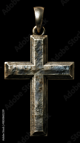 A vintage metal cross pendant with a raised border isolated on a black background, an ancient silver Christian symbol, a religious faith object, a heavy iron crucifix close-up.