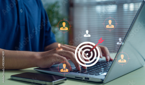 person working on laptop with digital target icons representing audience targeting, customer focus, business analysis, strategic marketing, and identifying the right user or client group effectively.