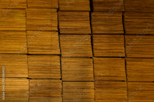 Close-up of thin wood veneer sheets stored in warehouse for manufacturing and industrial use.