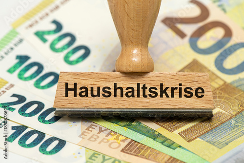 Wallpaper Mural Ein Holzstempel ist beschriftet mit dem Aufdruck Haushaltskrise als Symbolbild für Planung und Konzeption eines Finanzplans für den Haushalt - digital bearbeitet Torontodigital.ca