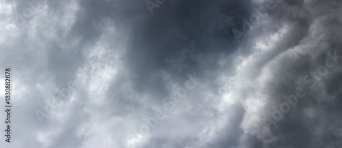Dark, gray clouds gather ominously in the daytime sky, creating a foreboding atmosphere. The scene captures the tension and drama of an approaching storm outdoors.