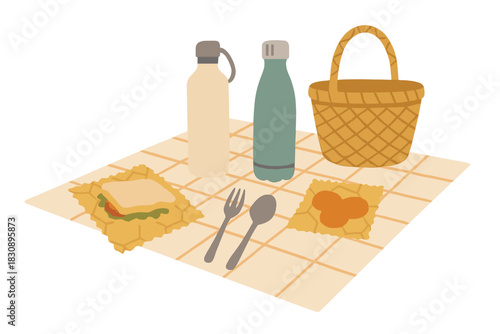 Sustainable picnic lunch setup with reusable bottles, food wraps, basket, and cutlery on a checkered blanket
