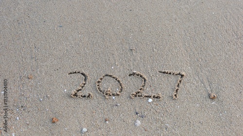 close up of year 2027 numbers written on the sand