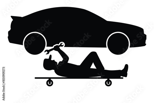 Silhouette of mechanic repairing car lying on creeper with wrench