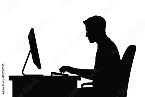 Silhouette of a man working at a computer desk