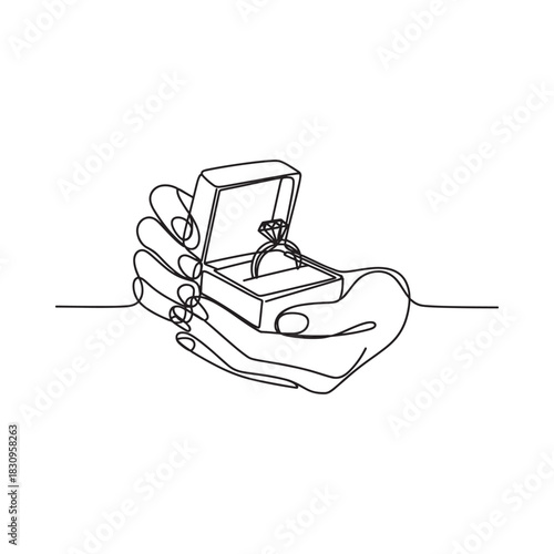 Hand holding open ring box with diamond engagement ring