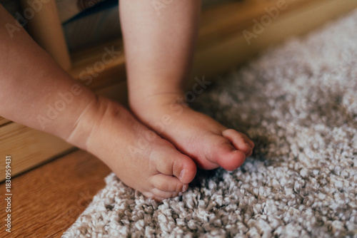 Close-up of a baby's feet in soft natural light. Tiny fingers and delicate skin create a warm, touching and cozy atmosphere. Great for themes about childhood, innocence, family life