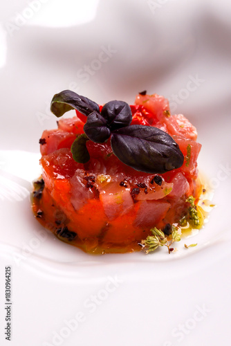 Tartare di tonno rosso e ricciola, guarnita con olio e granella di pistacchio e servita come antipasto in un ristorante elegante